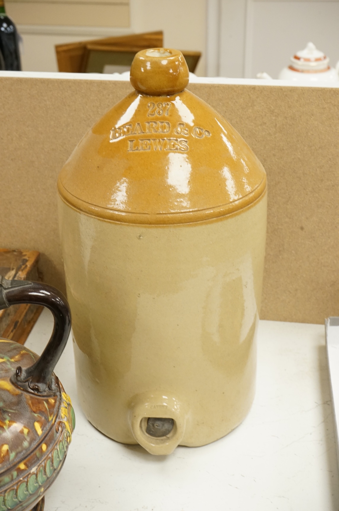 A German earthenware flagon, 32cm tall, together with a Beard & Co of Lewes stoneware liqueur flask